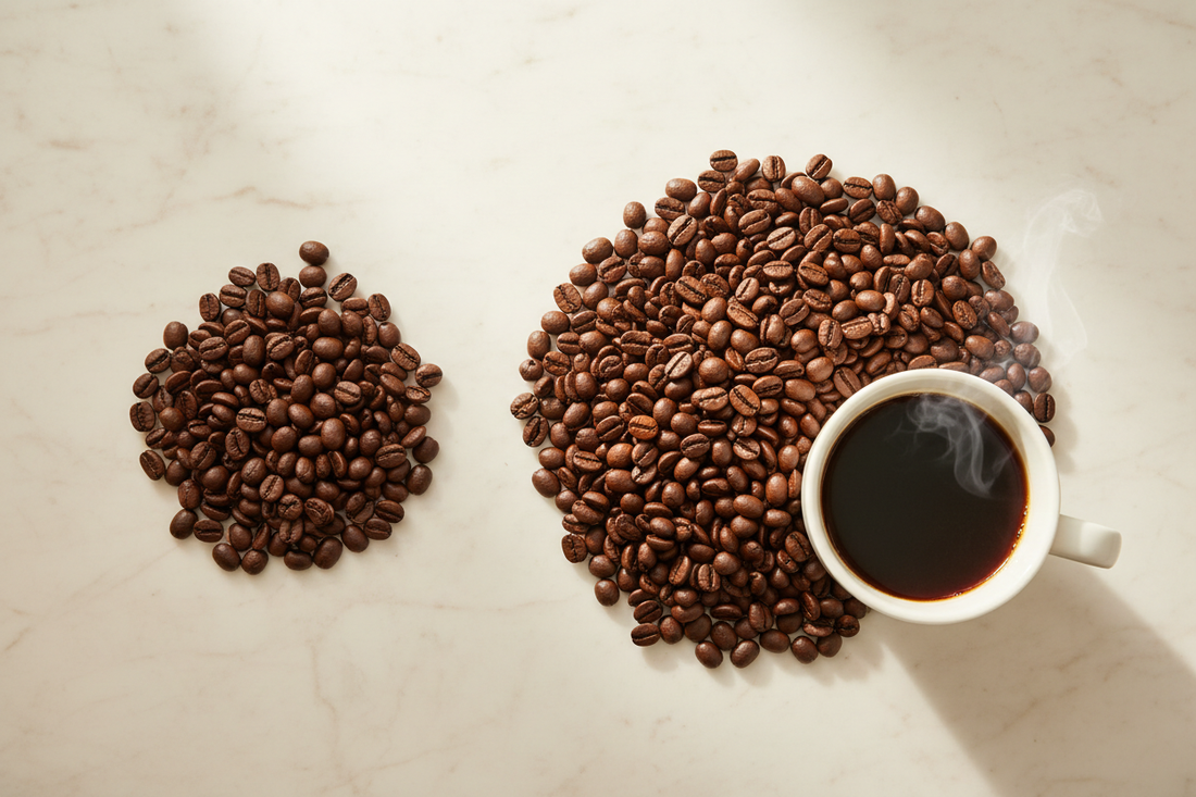 A clean side-by-side bean comparison on white marble — dull Robusta on the left, beautiful glossy Arabica on the right with a steaming mug.