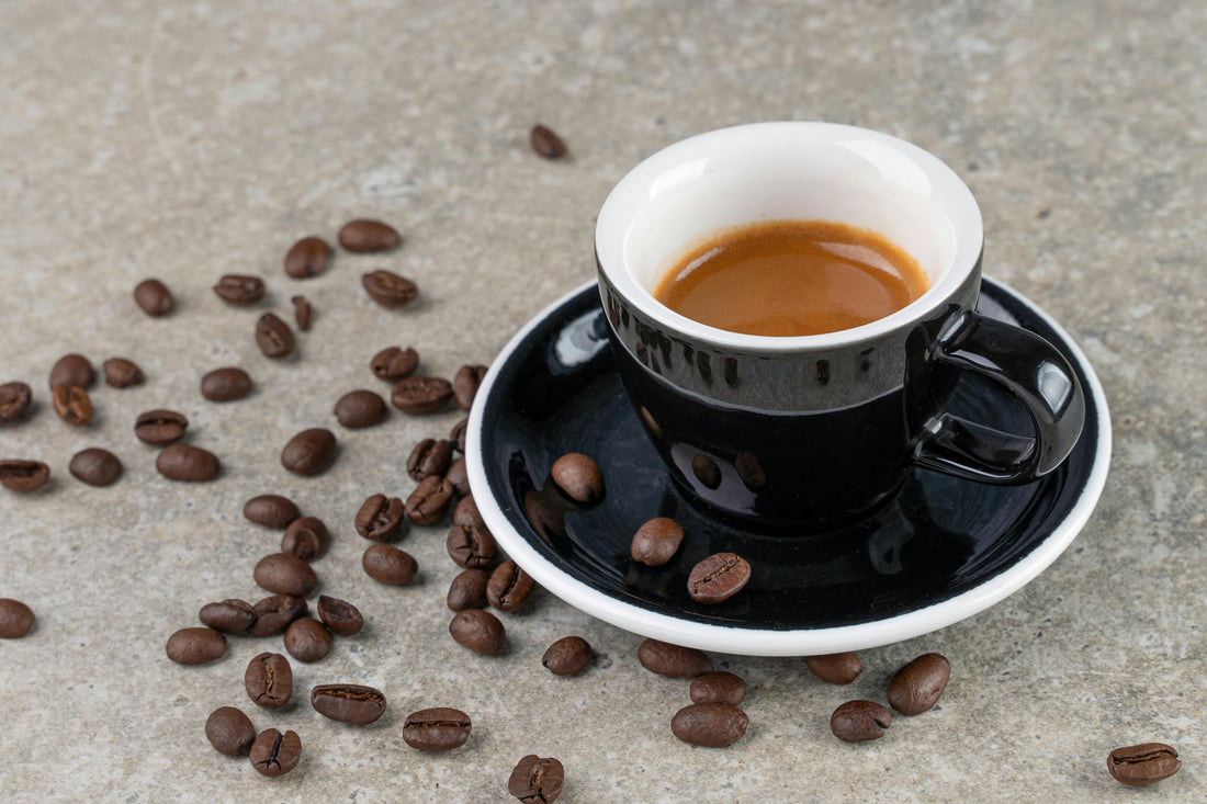 Clean background with espresso cup sitting on counter with fresh espresso beans