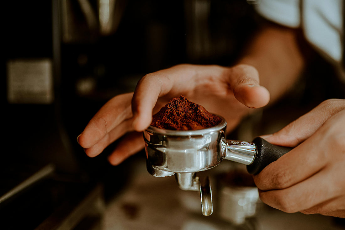 A person prepating espresso beans in an espresso puck 