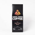 A tall black coffee box labeled Crema Peaks Coffee Dark Black Crest Blend, shown upright on a clean white background.