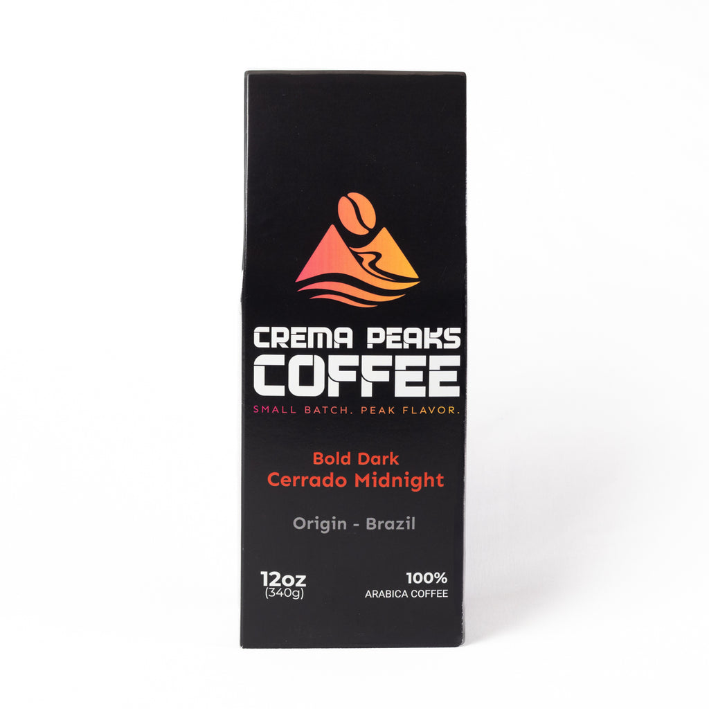 A tall, narrow black coffee package from Crema Peaks Coffee, featuring a colorful mountain logo and text for the Bold Dark Cerrado Midnight, on a clean white background.