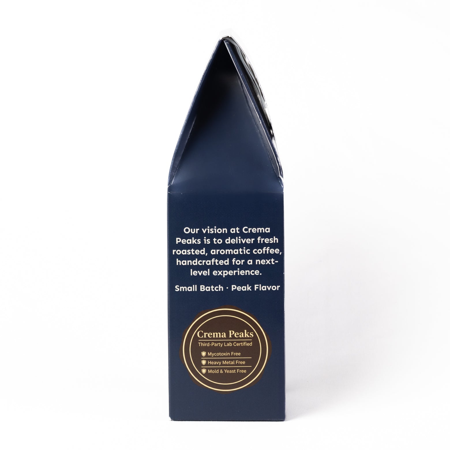 A tall, dark navy blue coffee bag packaging box shown from the back, featuring white descriptive text and a circular gold logo for Crema Peaks on a clean white background.