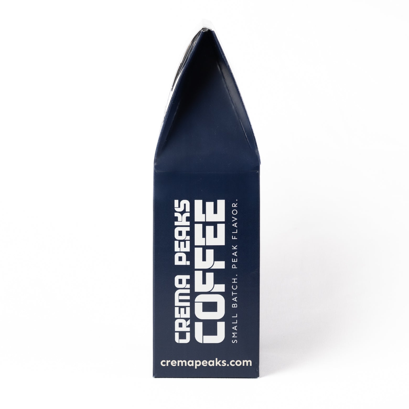 A dark navy blue coffee bag package standing upright on a white background, with large white vertical text reading 'CREMA PEAKS COFFEE' and smaller text 'SMALL BATCH, PEAK FLAVOR.' and 'cremapeaks.com