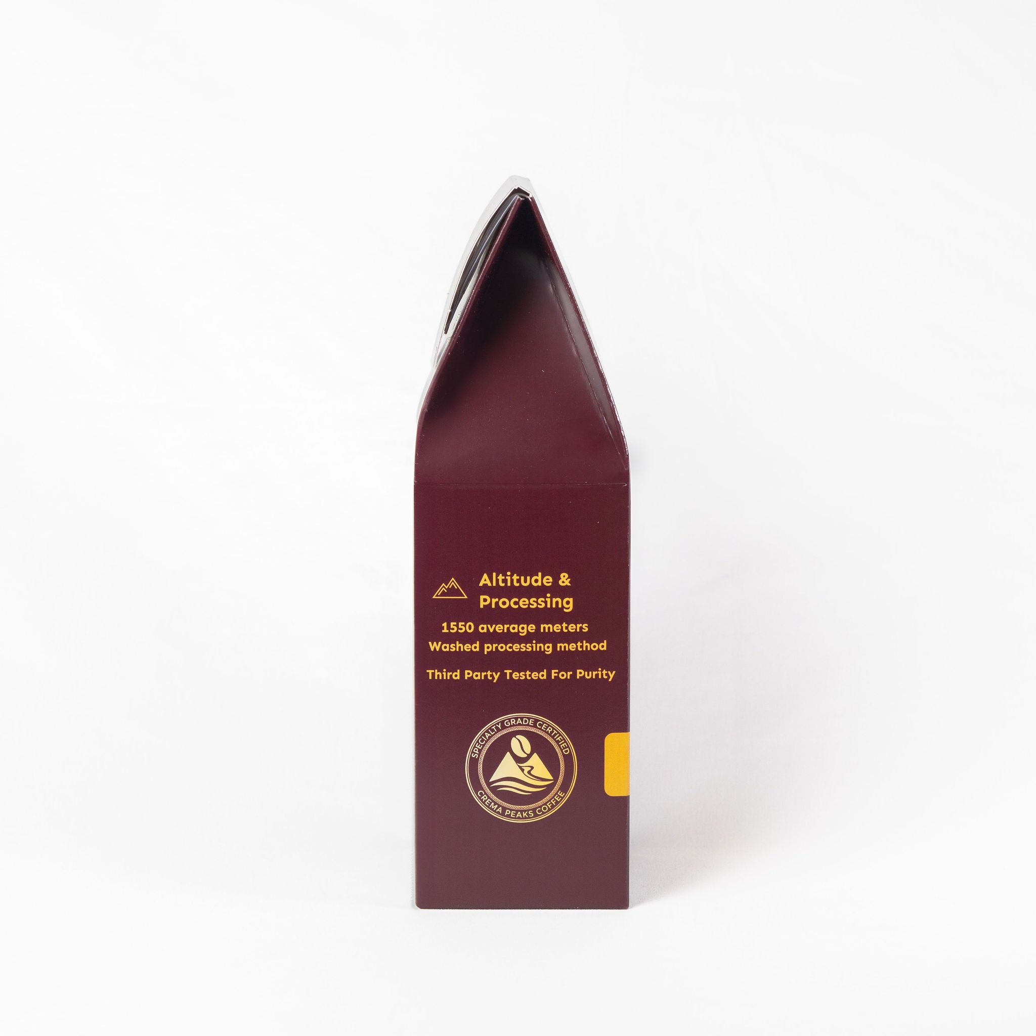 A tall, narrow dark burgundy package with gold text and a small yellow accent on the right side, photographed upright against a clean white background.