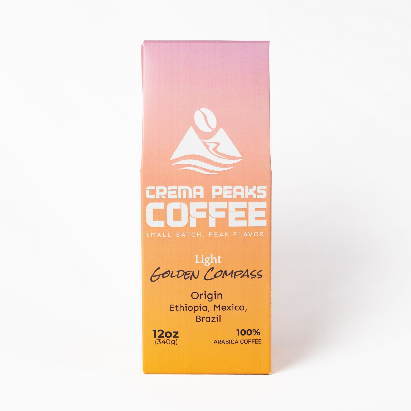 A 12oz box of Crema Peaks Coffee Light Golden Compass arabica coffee, featuring a pink-to-orange gradient packaging design with white and black text on a clean white background.