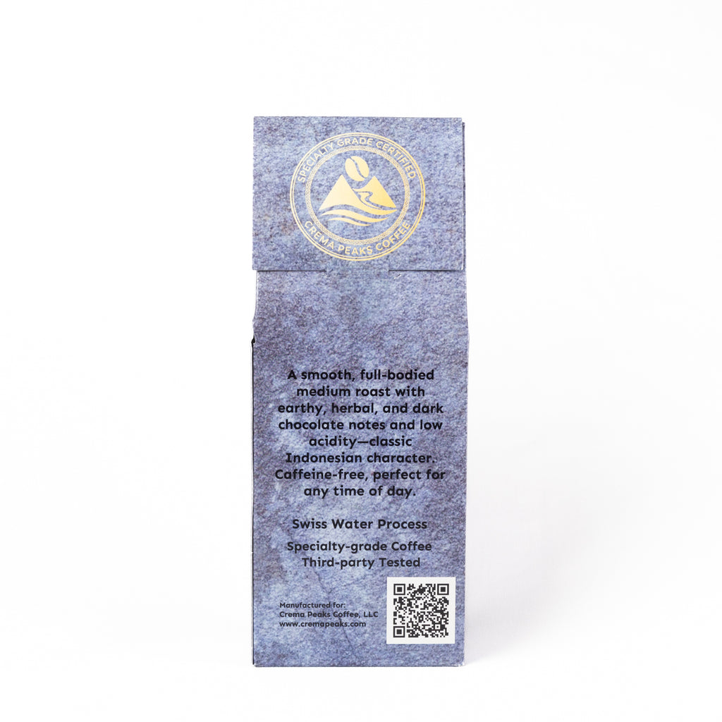 A tall, narrow gray paper sleeve or box with a gold circular logo near the top and black product description text on the front, photographed against a plain white background.