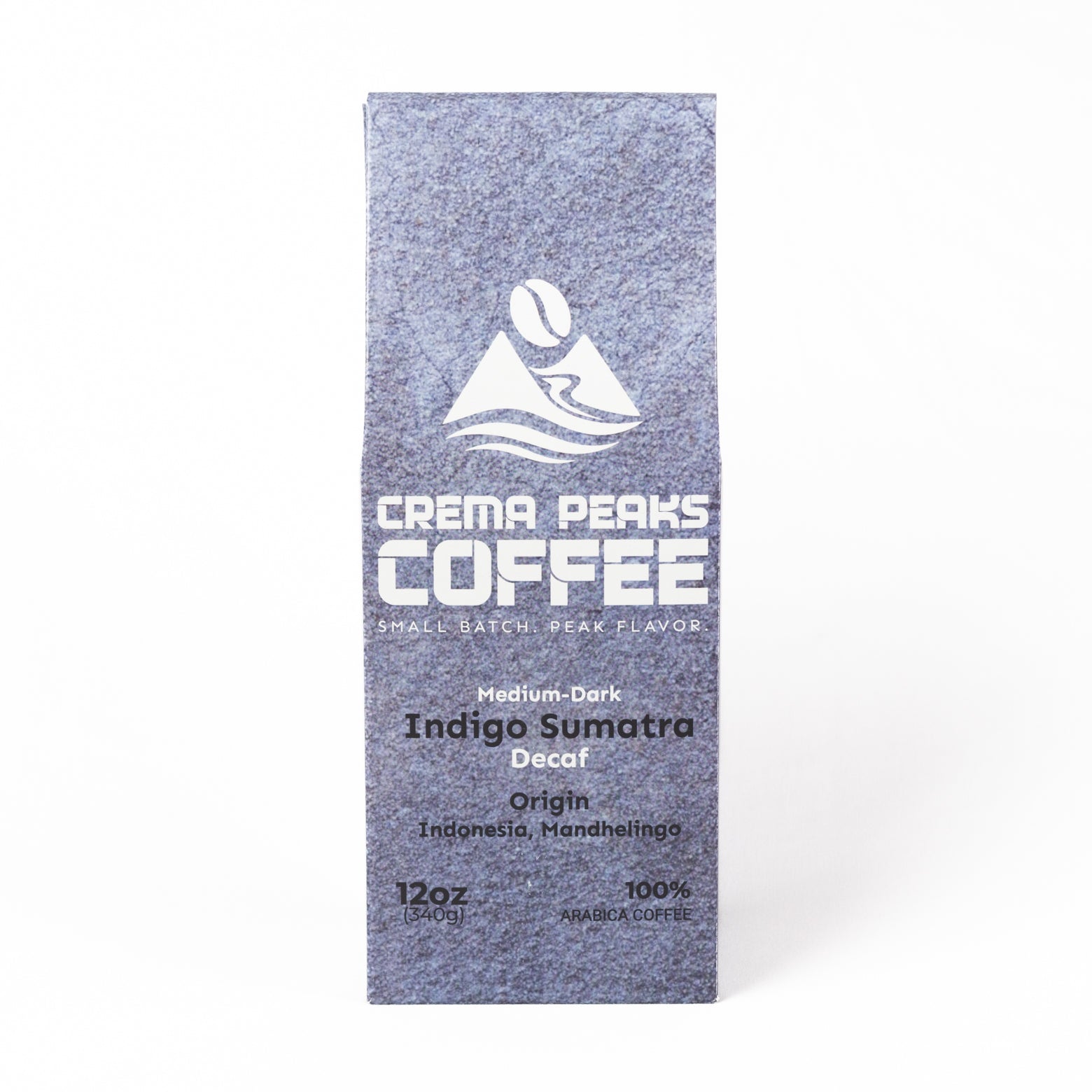 A tall, narrow coffee bag from Crema Peaks Coffee in the Indigo Sumatra Decaf coffee, featuring a textured slate-blue design with white text and logo, set against a plain white background.