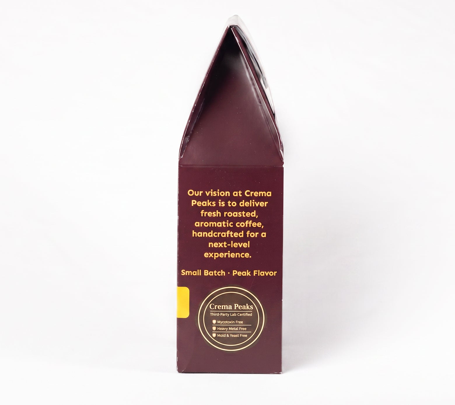 A tall, narrow dark burgundy coffee bag package standing upright on a white background, with gold text and a small yellow accent label on the front.