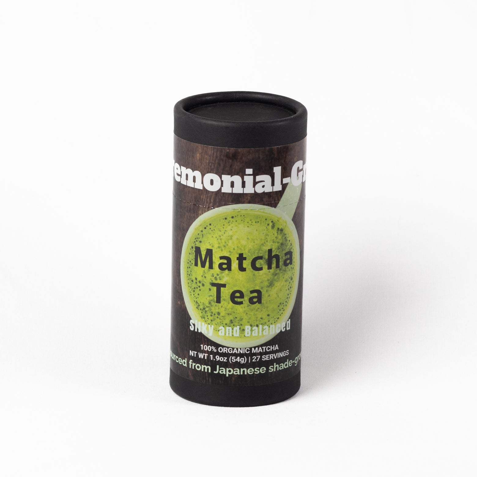 A cylindrical black container of organic ceremonial matcha tea with a dark label featuring a green matcha cup graphic and white text, photographed on a clean white background.