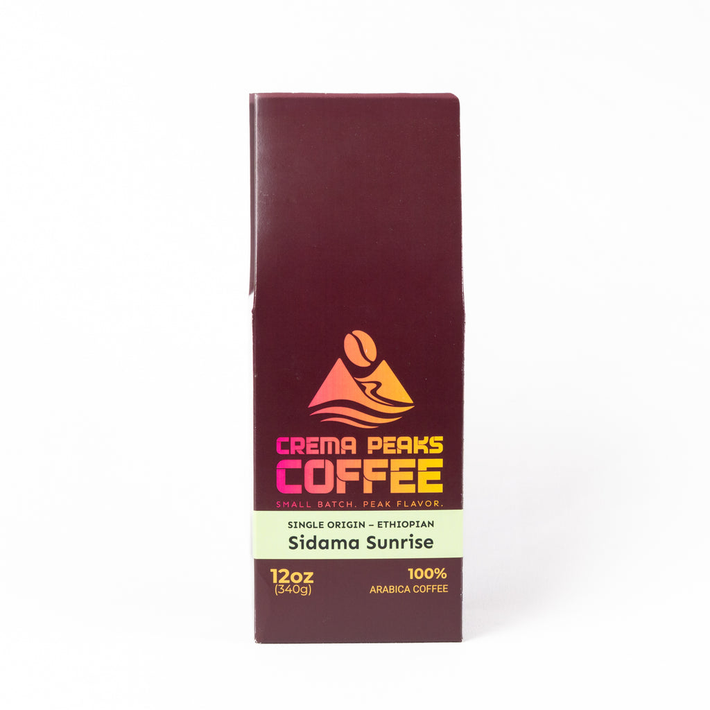 A tall rectangular coffee bag package for Crema Peaks Coffee, Sidama Sunrise, shown upright on a clean white background. The package is dark burgundy with a cream band and orange/yellow logo and text.